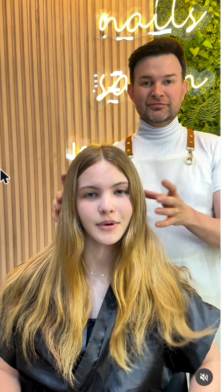 Ederson Garcia atendendo cliente com o painel de identidade visual do Nego Hair ao fundo