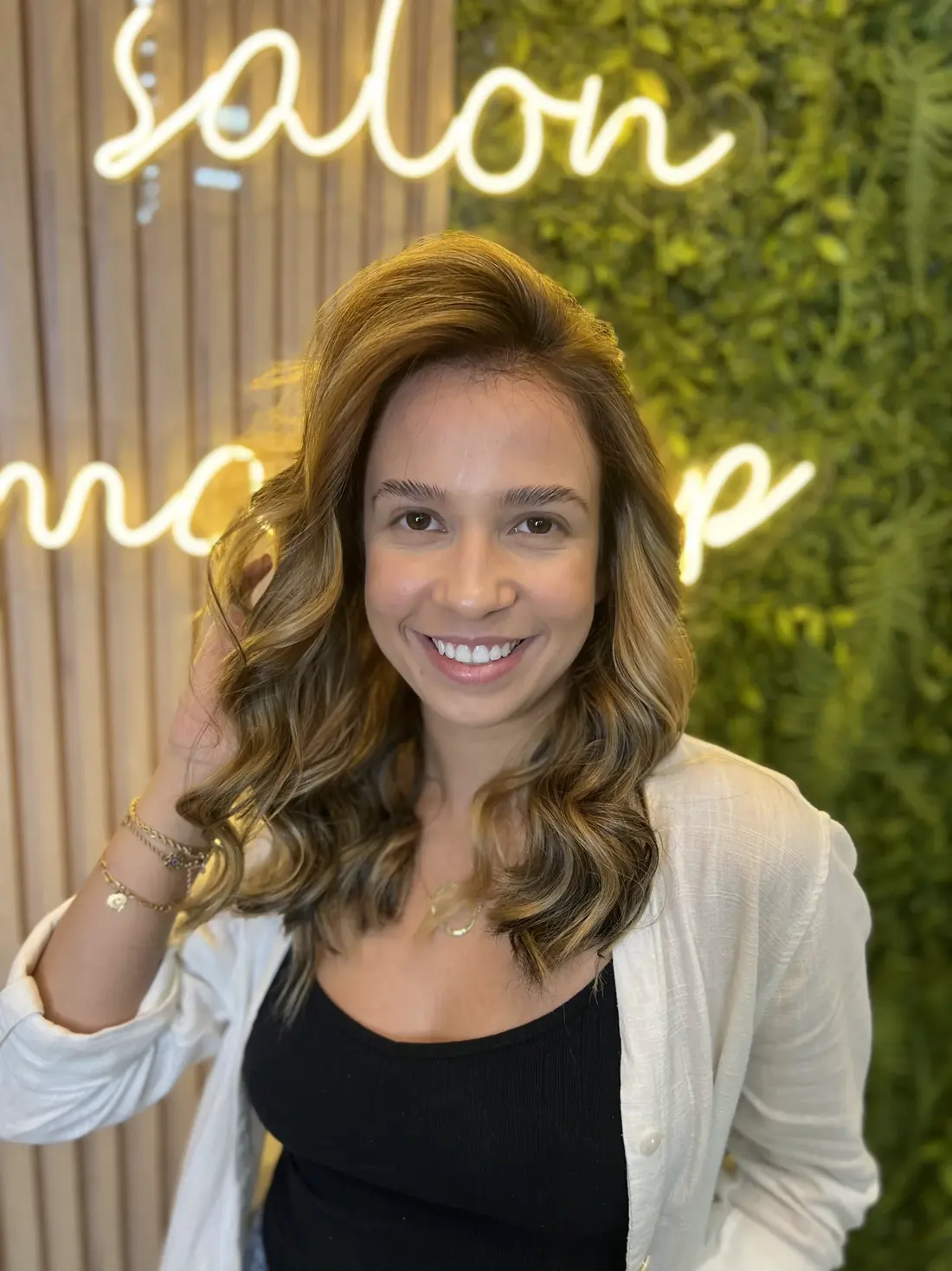 Cliente com cabelo caramelo ondulado, resultado de coloração