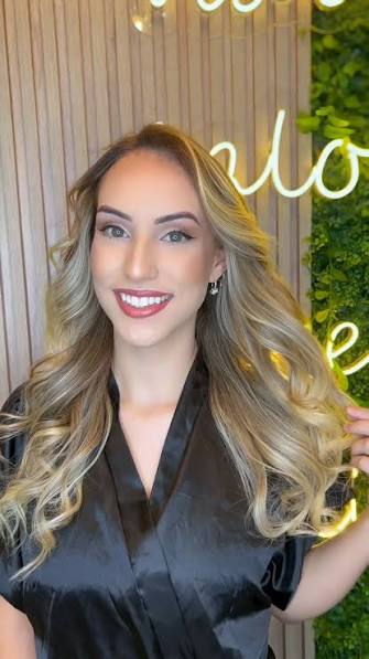 Cliente sorrindo com mechas loiras iluminadas
